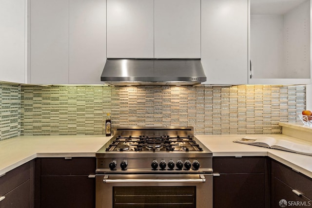 kitchen featuring backsplash, extractor fan, high end range, and white cabinetry