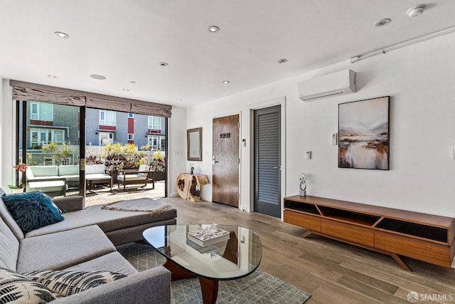 living room with hardwood / wood-style flooring and a wall mounted AC