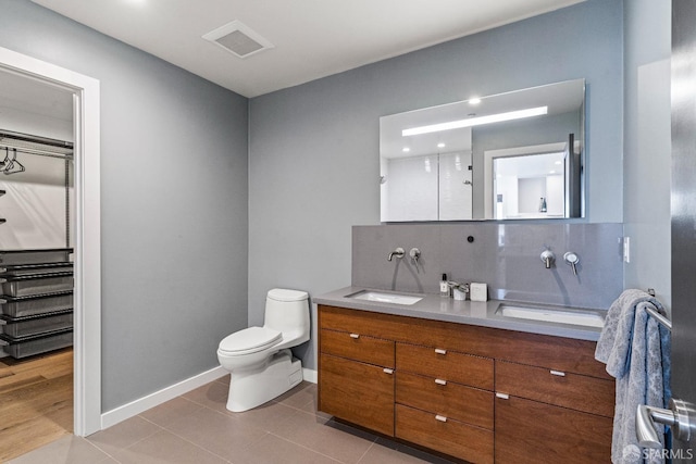 bathroom with backsplash, tile patterned floors, vanity, and toilet