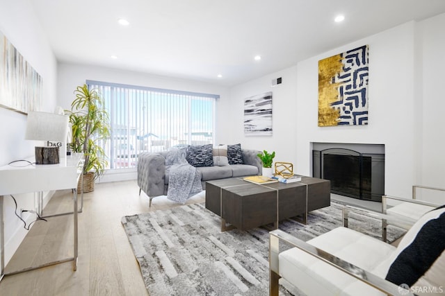 living room featuring recessed lighting, visible vents, wood finished floors, and a fireplace