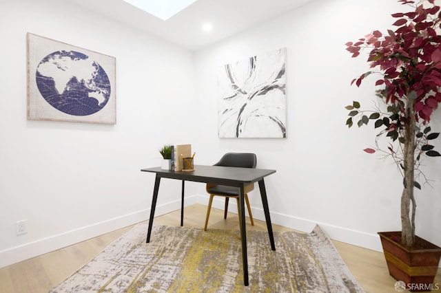 office with wood finished floors, baseboards, a skylight, and recessed lighting