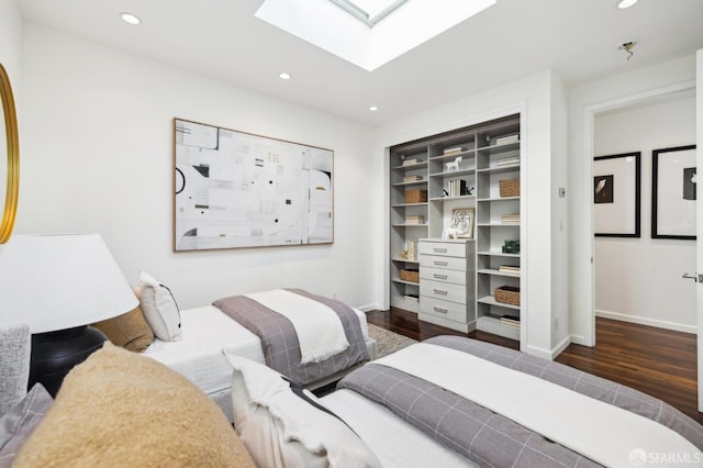 bedroom with a skylight, recessed lighting, wood finished floors, and baseboards