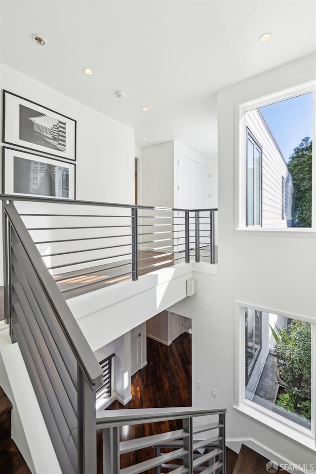 staircase with recessed lighting and wood finished floors