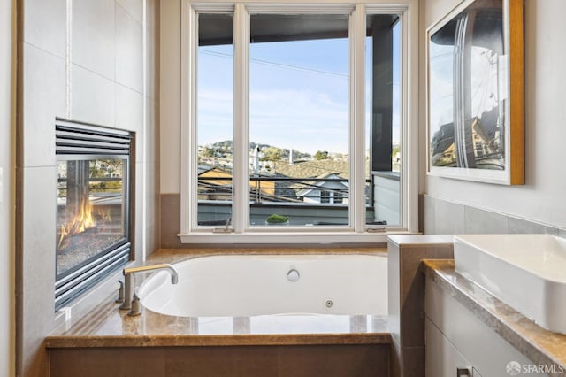 bathroom featuring a tub with jets and vanity