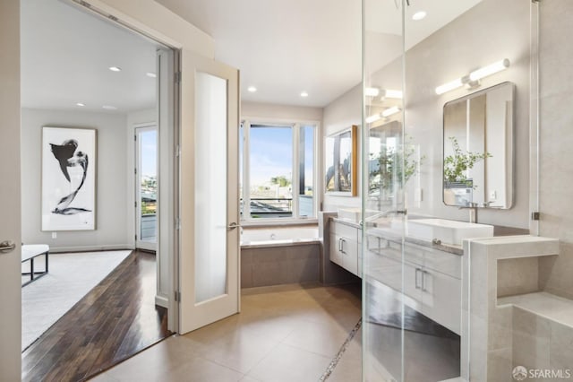 bathroom featuring a bath, recessed lighting, and vanity