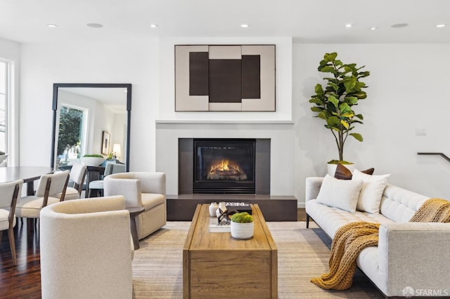 living area featuring recessed lighting, a glass covered fireplace, and light wood finished floors