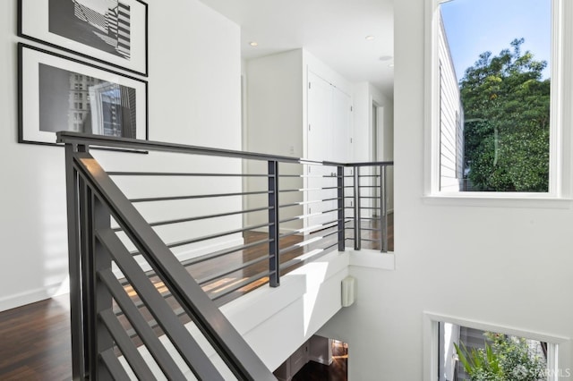 hallway featuring dark wood-type flooring, recessed lighting, and baseboards