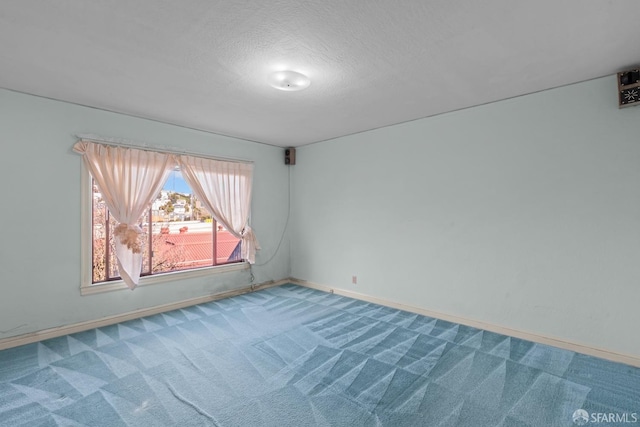 spare room with carpet flooring and a textured ceiling