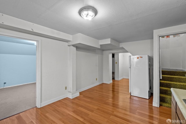 bonus room with light hardwood / wood-style flooring and a textured ceiling