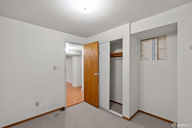 unfurnished bedroom with a closet, a textured ceiling, and carpet