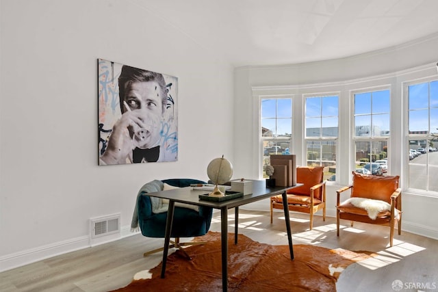 interior space with visible vents, baseboards, and wood finished floors