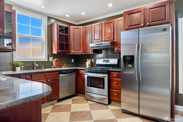 kitchen with light floors, a sink, stainless steel appliances, glass insert cabinets, and under cabinet range hood