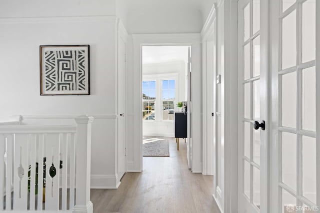 hallway with baseboards and light wood-style floors