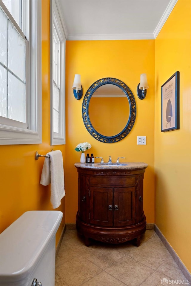 bathroom featuring baseboards, ornamental molding, and vanity