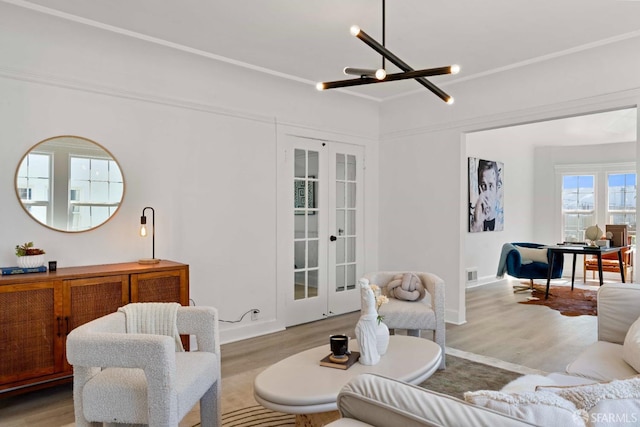 living area featuring wood finished floors, french doors, and baseboards