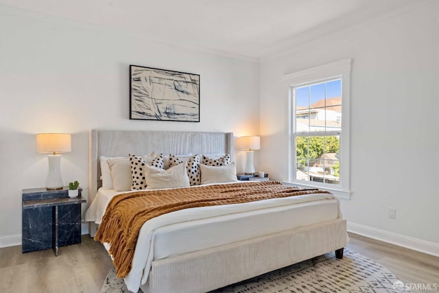 bedroom featuring wood finished floors and baseboards
