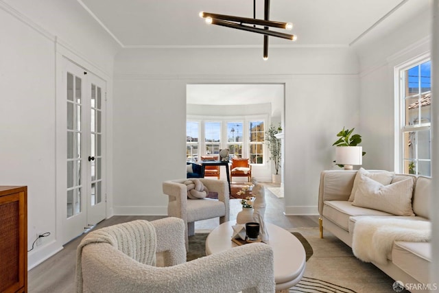 living area featuring wood finished floors, baseboards, french doors, and a chandelier