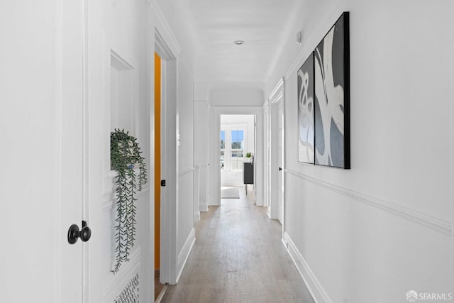 hallway with light wood-style flooring and baseboards