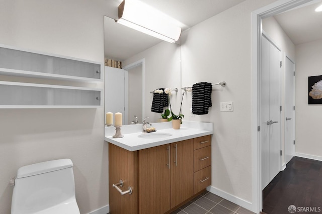 bathroom with wood-type flooring, vanity, and toilet