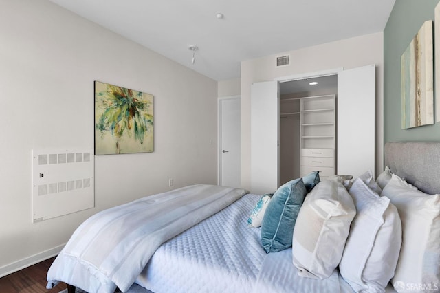 bedroom with a closet, a spacious closet, and wood-type flooring