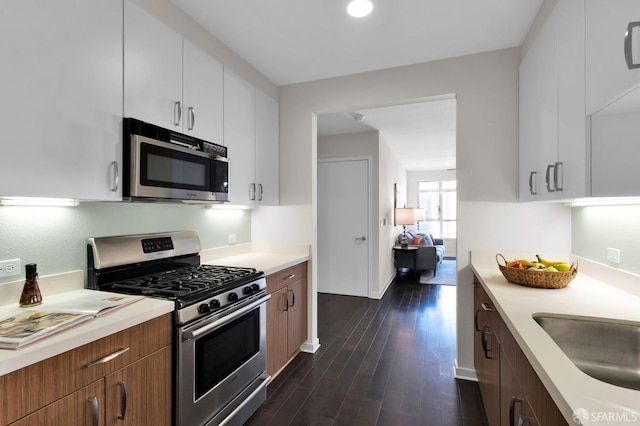 kitchen with white cabinets, stainless steel appliances, dark wood-type flooring, and sink