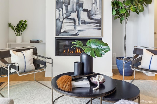 interior space featuring wood finished floors and a glass covered fireplace