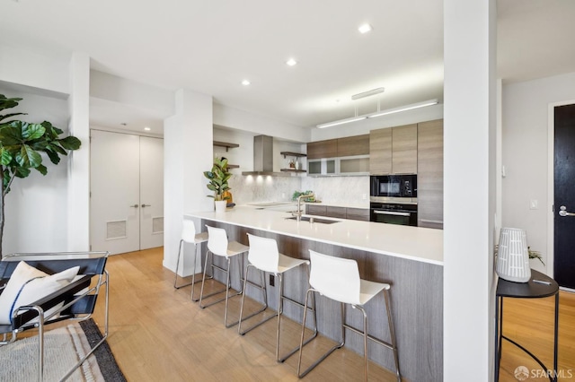 kitchen with modern cabinets, a kitchen breakfast bar, a peninsula, light countertops, and open shelves