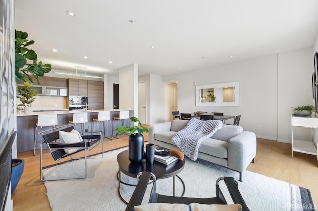 living area featuring light wood-type flooring and recessed lighting