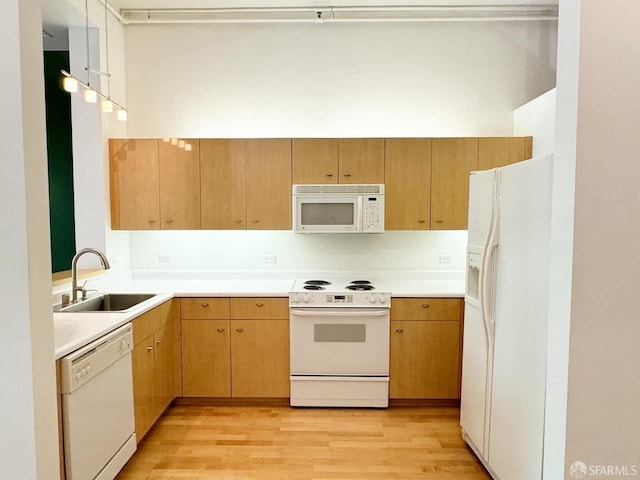 kitchen with white appliances, light hardwood / wood-style floors, and sink