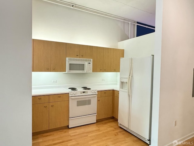 kitchen with light wood-type flooring and white appliances