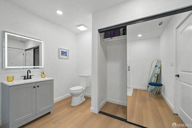 3901 La Colina Rd, El Sobrante, CA 94803 - bathroom with wood finished floors, vanity, toilet, baseboards, and recessed lighting
