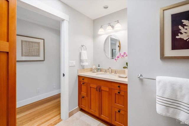 bathroom featuring baseboards, wood finished floors, and vanity