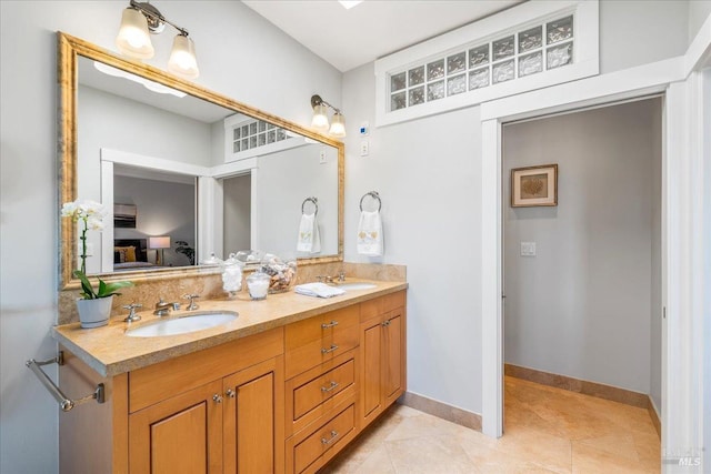 bathroom featuring double vanity, tile patterned flooring, baseboards, and a sink