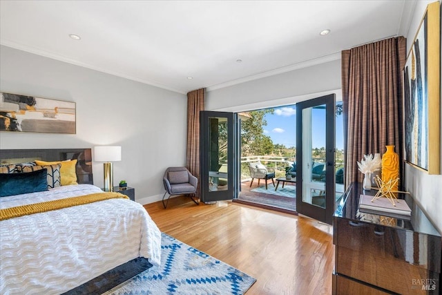 bedroom featuring access to exterior, baseboards, ornamental molding, and wood finished floors