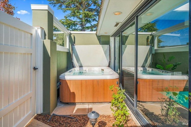 view of patio featuring visible vents and a hot tub