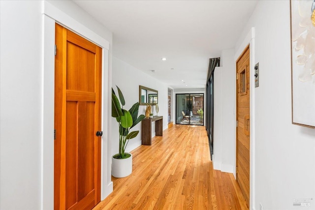 corridor with light wood-type flooring and recessed lighting