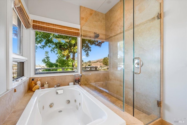 bathroom with a jetted tub and a shower stall