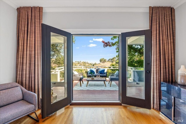 doorway featuring light wood-style flooring and crown molding