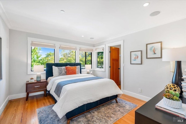 bedroom featuring light wood-type flooring, baseboards, crown molding, and recessed lighting