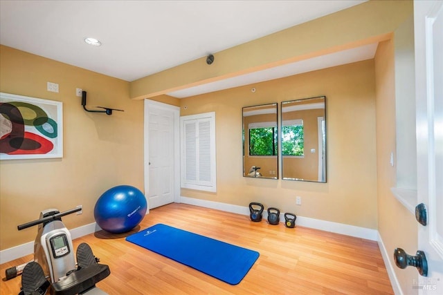 exercise room with baseboards and wood finished floors