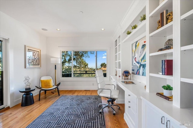 office with recessed lighting, wood finished floors, baseboards, built in features, and built in desk