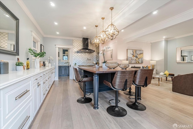 kitchen with light countertops, recessed lighting, decorative backsplash, and wall chimney exhaust hood