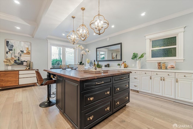 interior space featuring white cabinets, light wood finished floors, an inviting chandelier, wood counters, and dark cabinetry