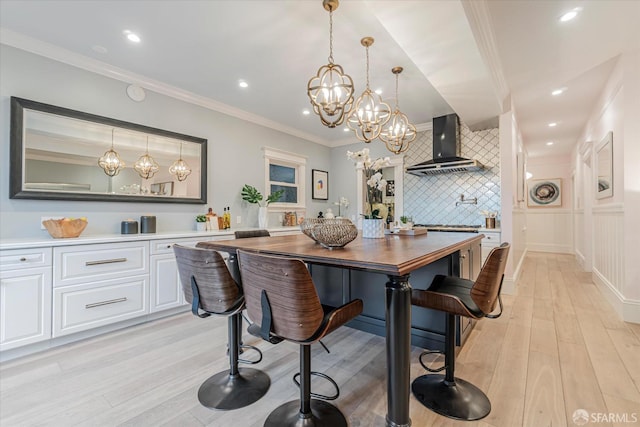dining room featuring an inviting chandelier, crown molding, recessed lighting, and light wood-style flooring