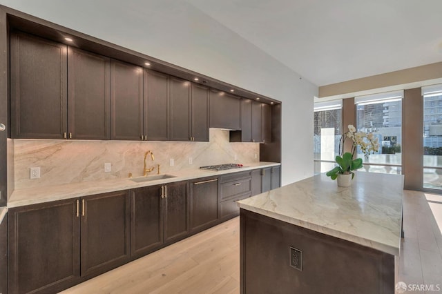 288 Pacific Ave Unit 4E, San Francisco, CA 94111 - kitchen with a sink, tasteful backsplash, light wood finished floors, lofted ceiling, and light stone counters