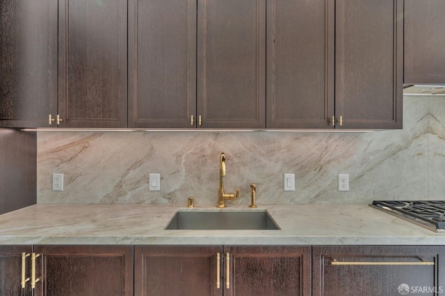 288 Pacific Ave Unit 4E, San Francisco, CA 94111 - kitchen with tasteful backsplash, stainless steel gas cooktop, dark brown cabinetry, and range hood