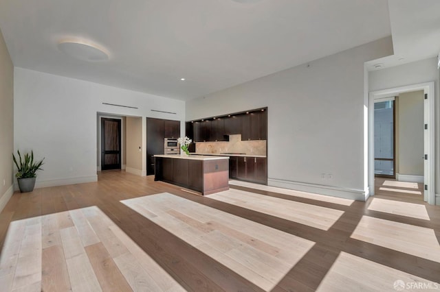288 Pacific Ave Unit 4E, San Francisco, CA 94111 - kitchen with a center island, light countertops, dark brown cabinetry, light wood finished floors, and open floor plan