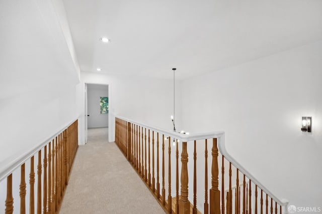 corridor with recessed lighting, a wainscoted wall, an upstairs landing, and light colored carpet