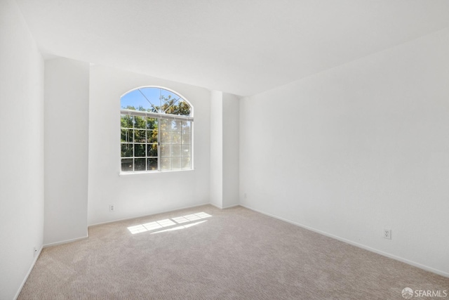 empty room with baseboards and light carpet