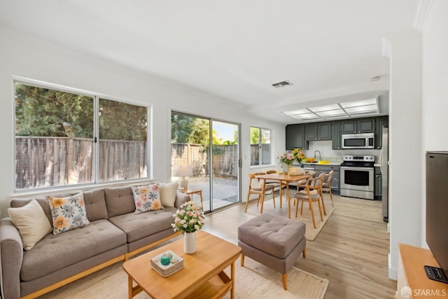 living area with visible vents and light wood-style flooring